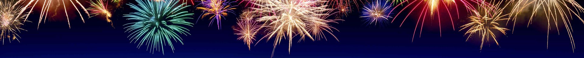 Farverige fyrværkerier eksploderer mod en mørkeblå baggrund. De lysegnistrende lys stråler i forskellige former og farver, hvilket skaber en festlig stemning, der ofte er forbundet med fejringer og specielle lejligheder.